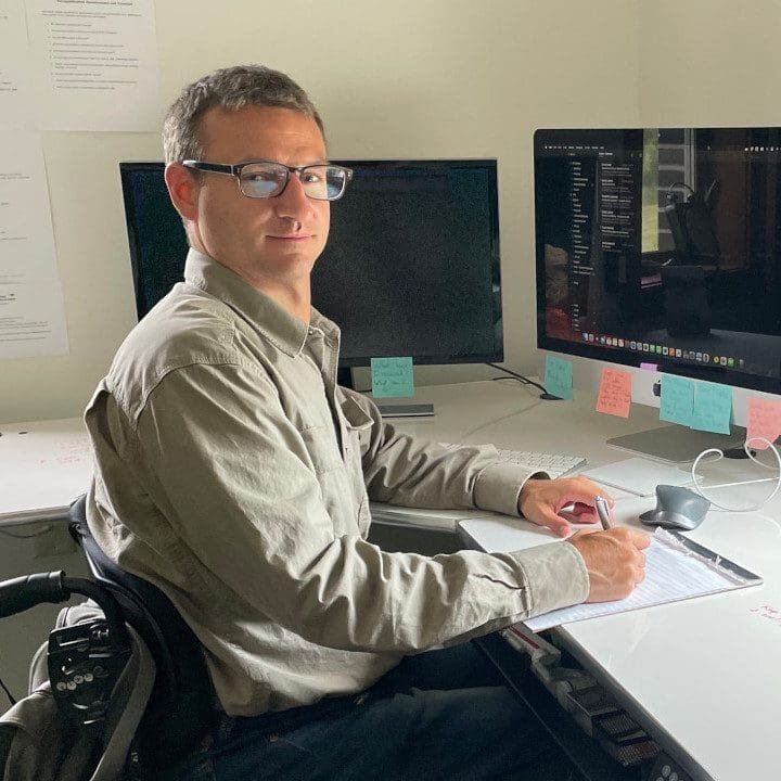 A man sitting in front of a computer desk.